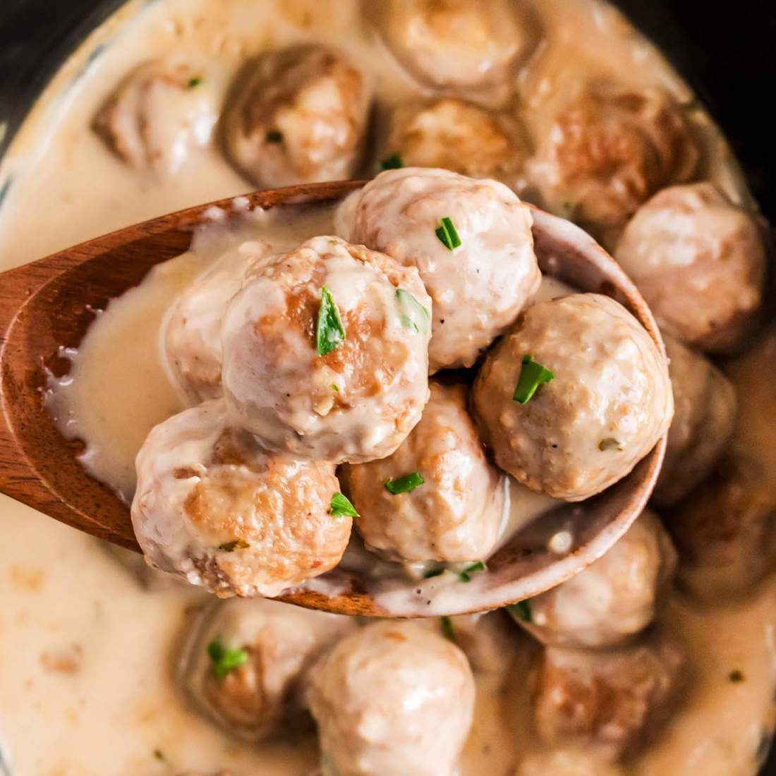 Tender slow‑cooked Swedish meatballs simmering in a creamy gravy inside a crockpot