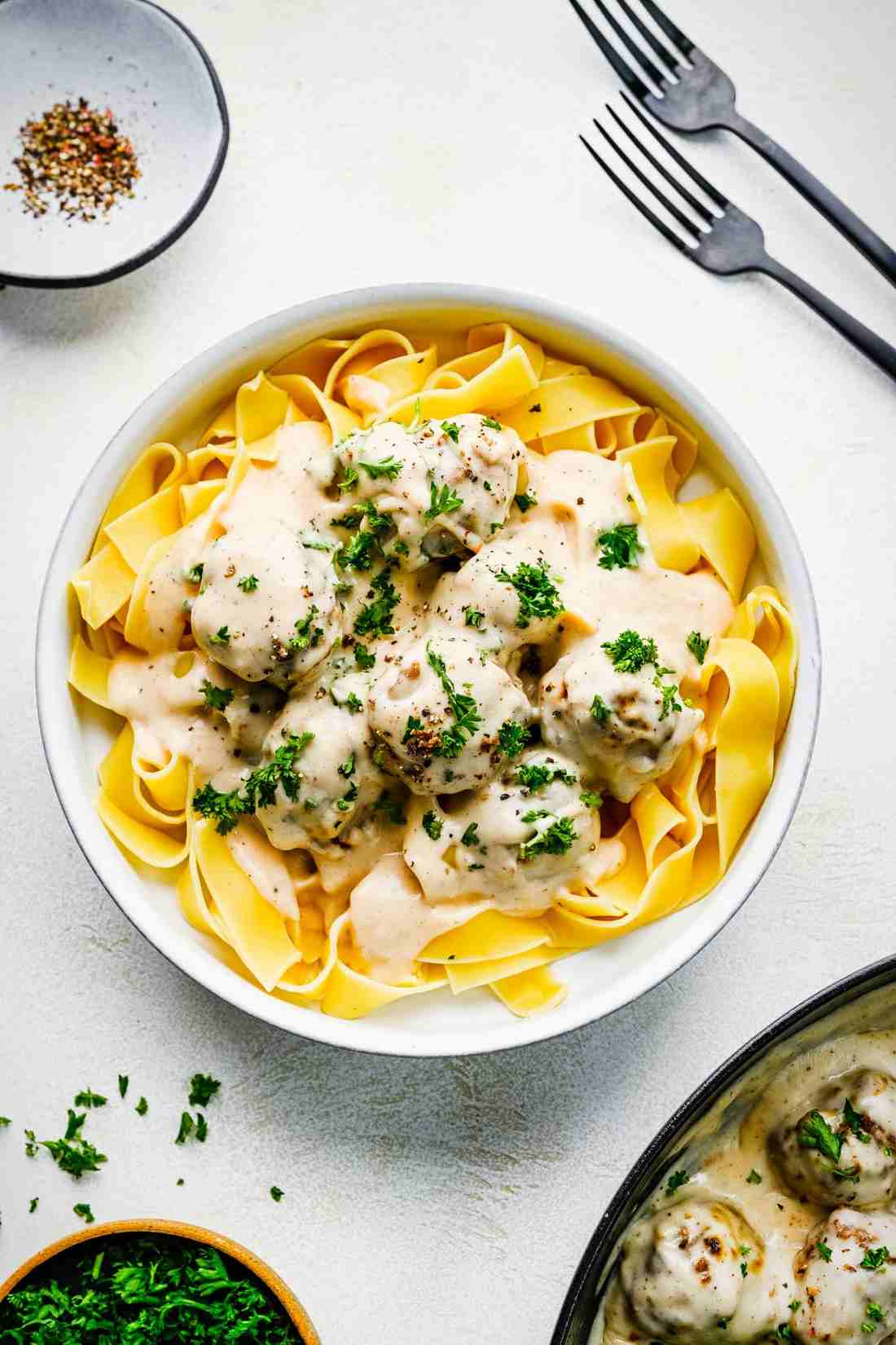 Pan of tiny buttered German spaetzle dumplings topped with savory Swedish meatballs and cream gravy