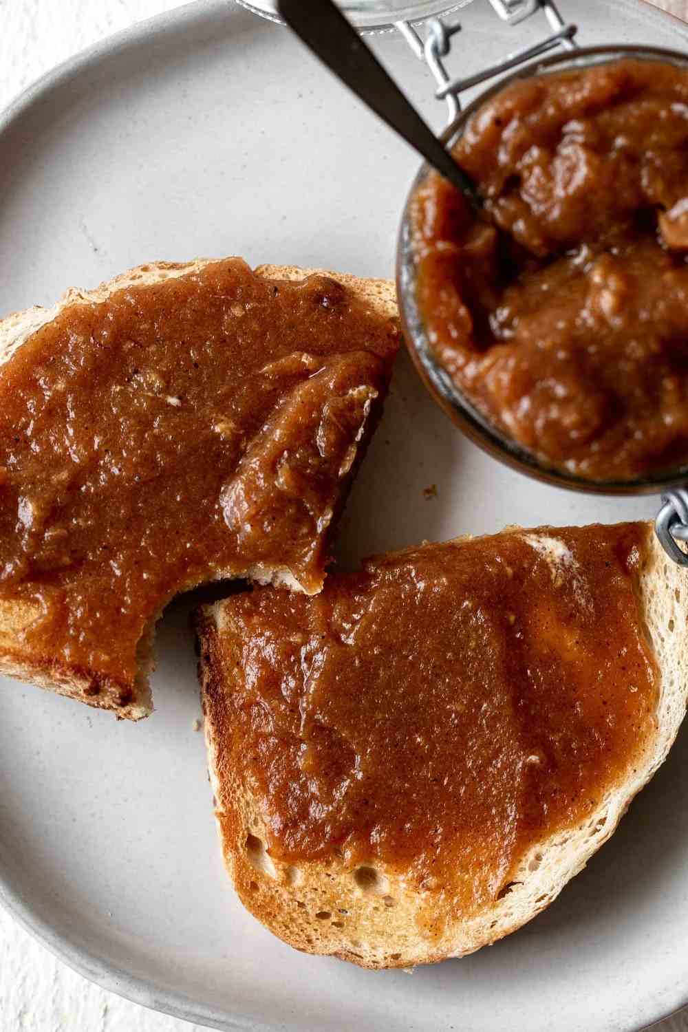 Creamy apple butter in a mason jar, golden hue, aromatic spices, ideal for autumn spreads