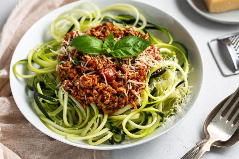 Low‑carb bolognese with cauliflower rice, beef, parmesan, fresh basil, rich tomato sauce.