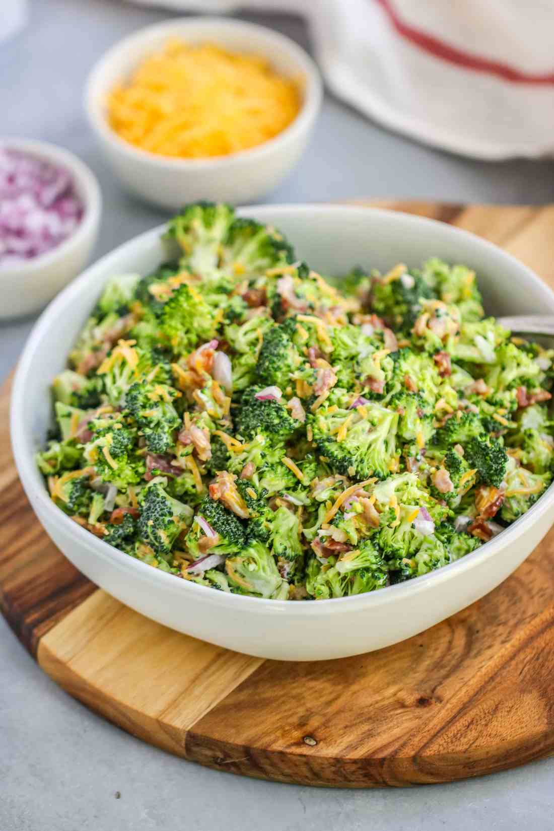 Classic broccoli salad with crisp florets, sunflower seeds, shredded cheddar, red onion, raisins, and creamy mayo dressing
