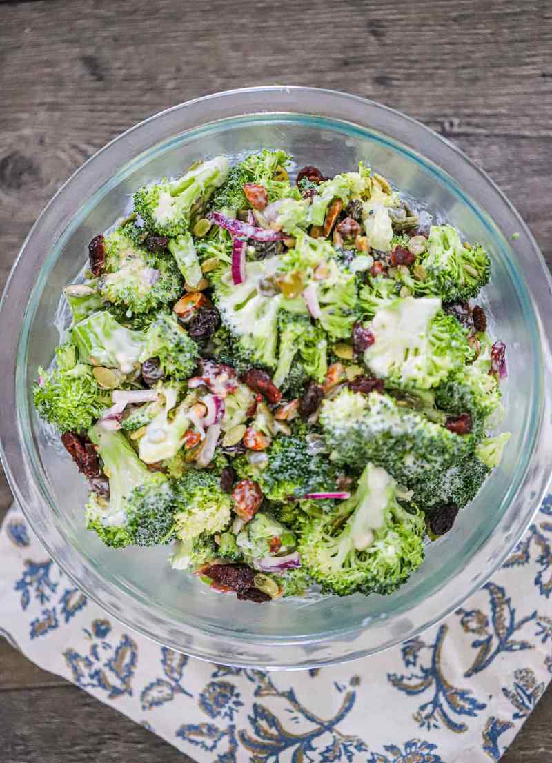 Vegan broccoli salad with florets, ginger‑lime dressing, toasted walnuts, dried cranberries, and vegan cheese crumble