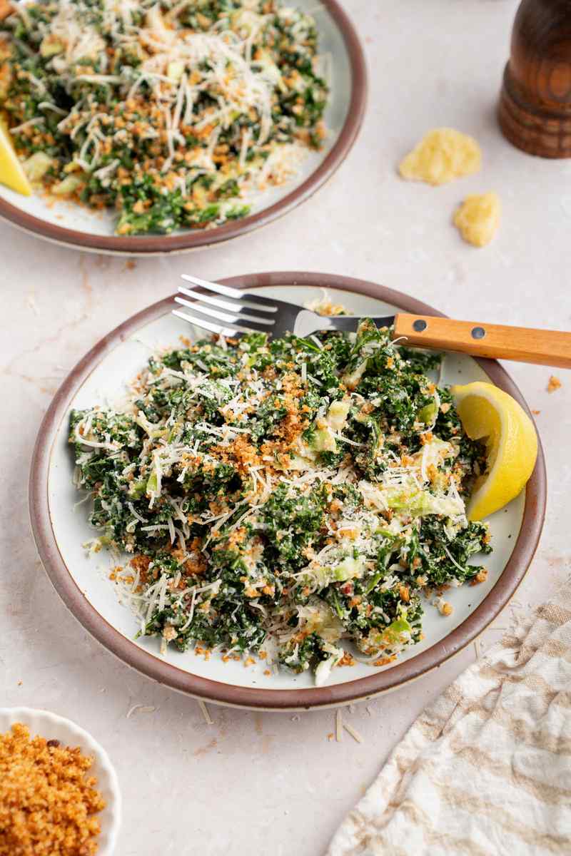 Massaged tuscan kale caesar salad with dark green dinosaur kale leaves parmesan and crunchy croutons