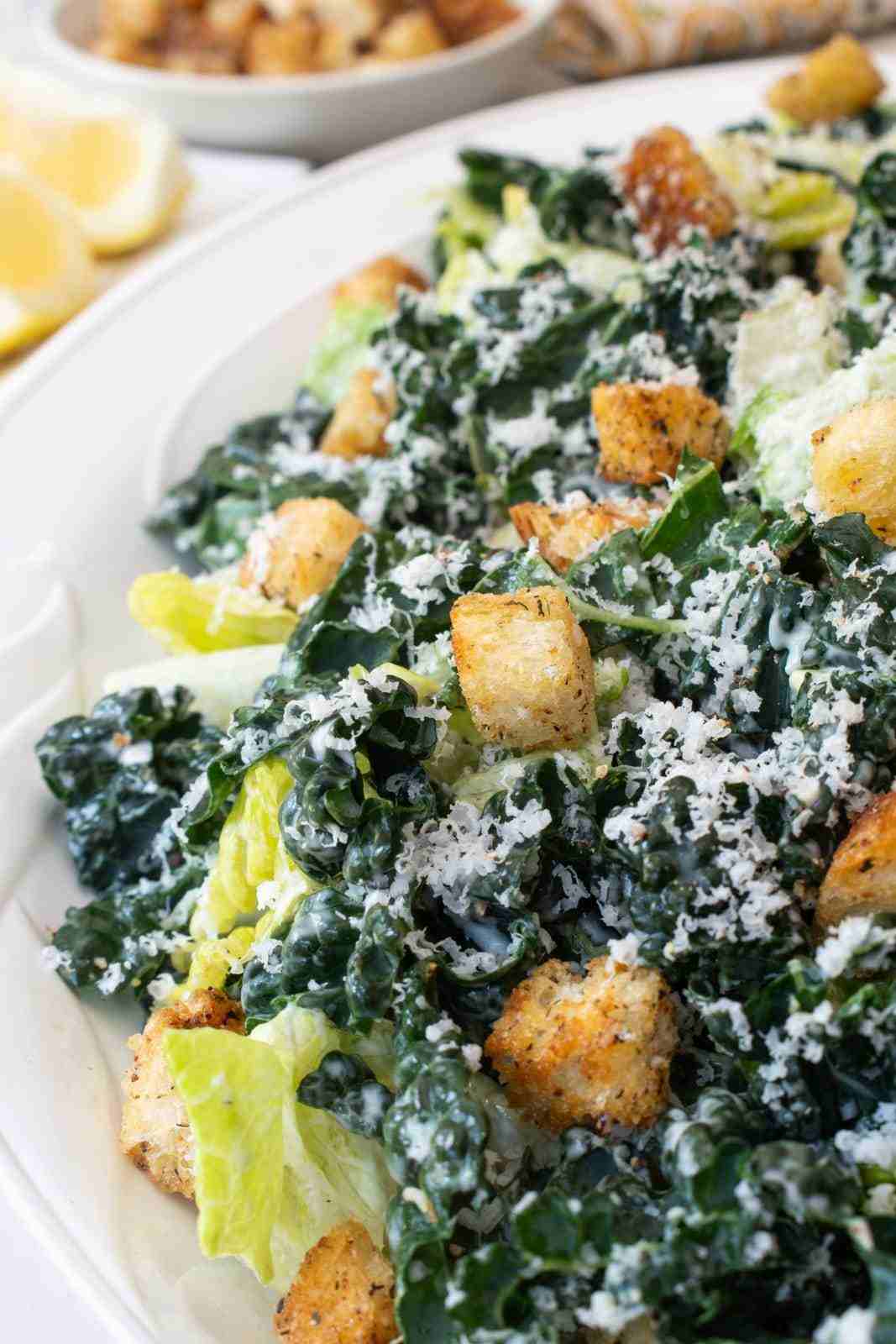 Shaved brussels sprout and kale caesar salad with shredded greens parmesan cheese and crunchy croutons