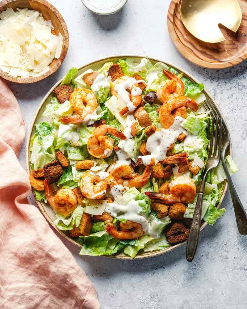 Blackened cajun shrimp caesar salad with spicy charred shrimp crisp romaine and shaved parmesan