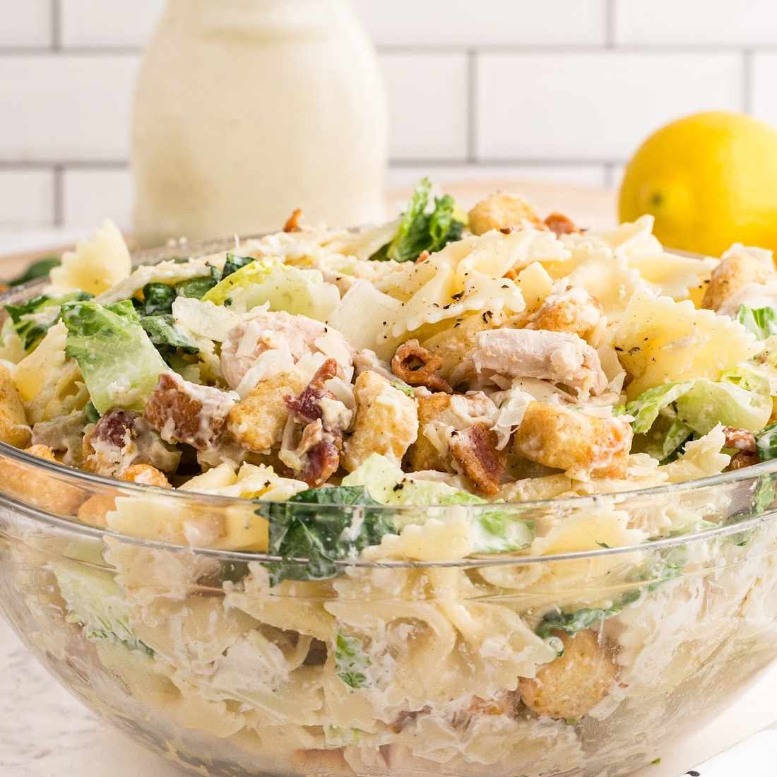 Hearty chicken caesar pasta salad loaded with crisp romaine, crunchy croutons, shaved parmesan, creamy dressing.