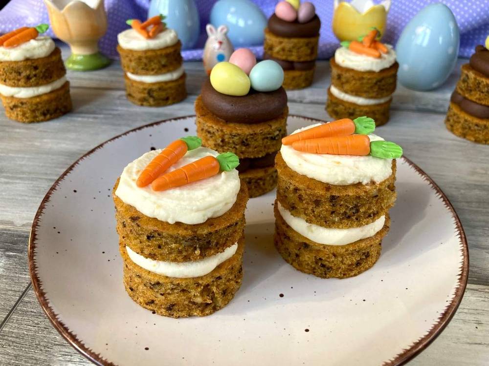 Easter carrot cake cupcakes topped with pastel buttercream, fresh carrots, and sweet spring sprinkles