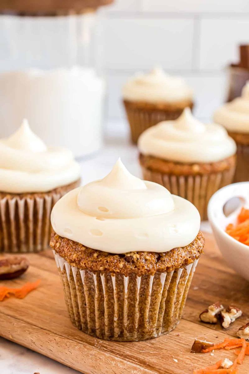 Carrot cupcakes crowned with creamy frosting and generous chopped pecan topping