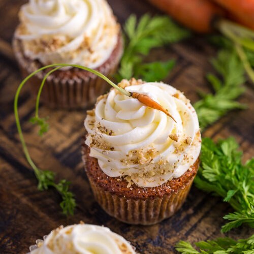 Carrot cupcake adorned with fresh carrot ribbons, moist spiced crumb, and creamy frosting