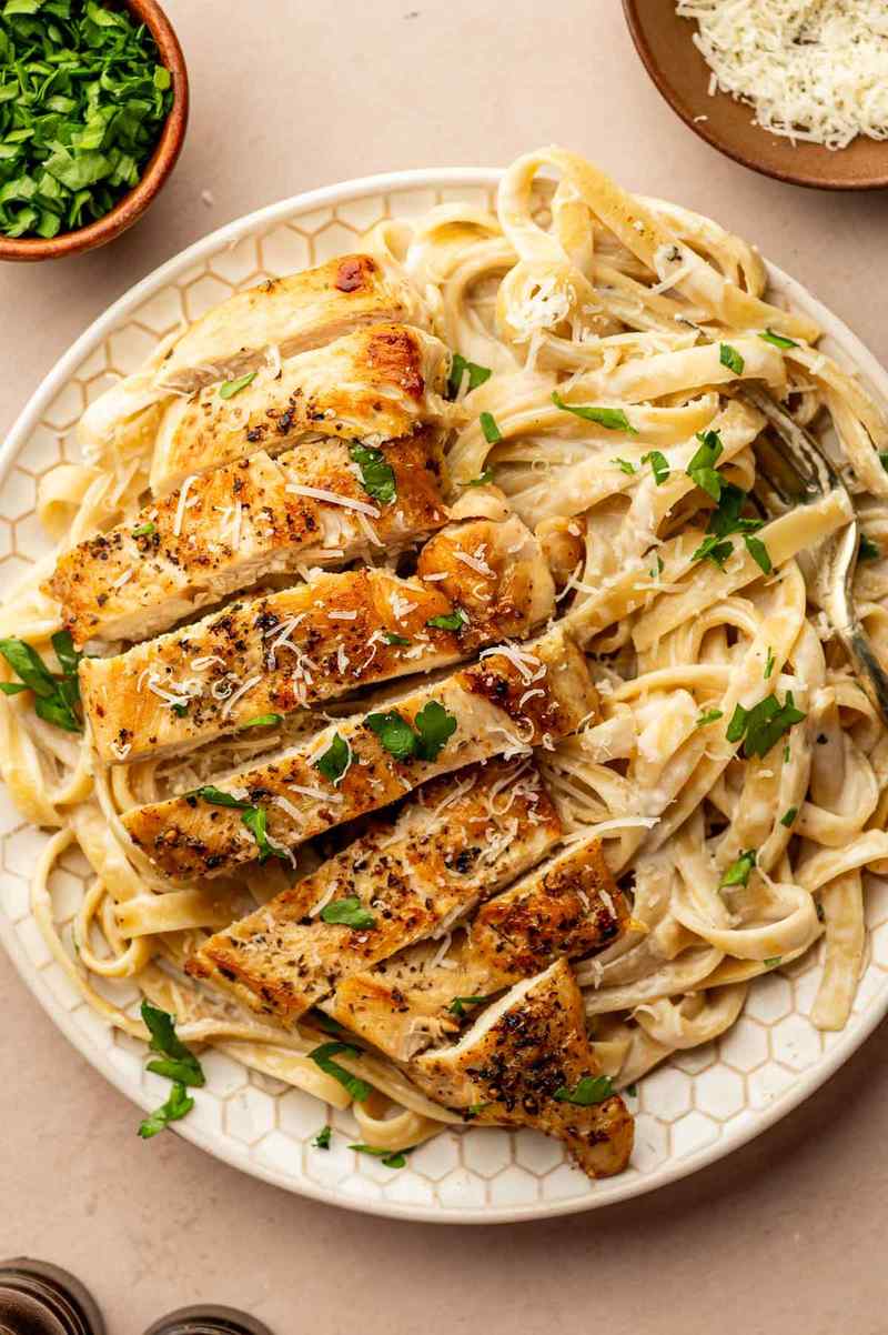 Silky parmesan cream sauce coating fettuccine and succulent chicken pieces, creamy pasta perfection