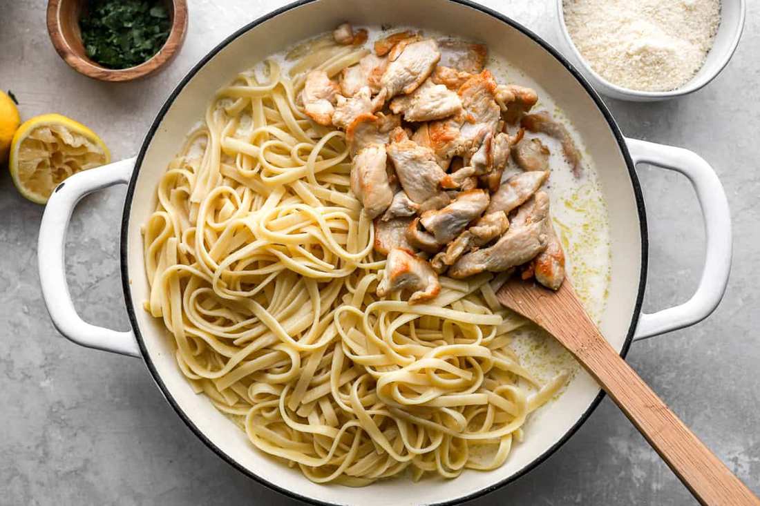 Classic fettuccine chicken alfredo showcasing tender chicken, silky parmesan cream sauce, and tender fettuccine.