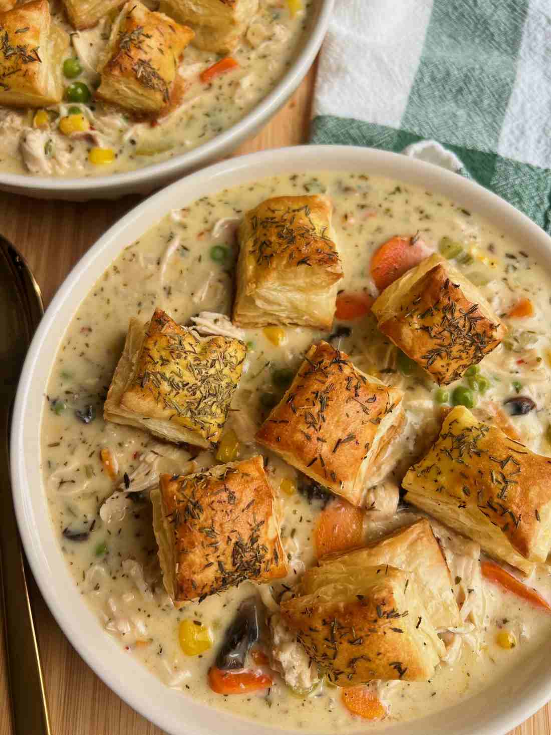 Creamy chicken pot pie soup with chicken, peas, carrots, potatoes, and cheddar‑topped biscuit crumble