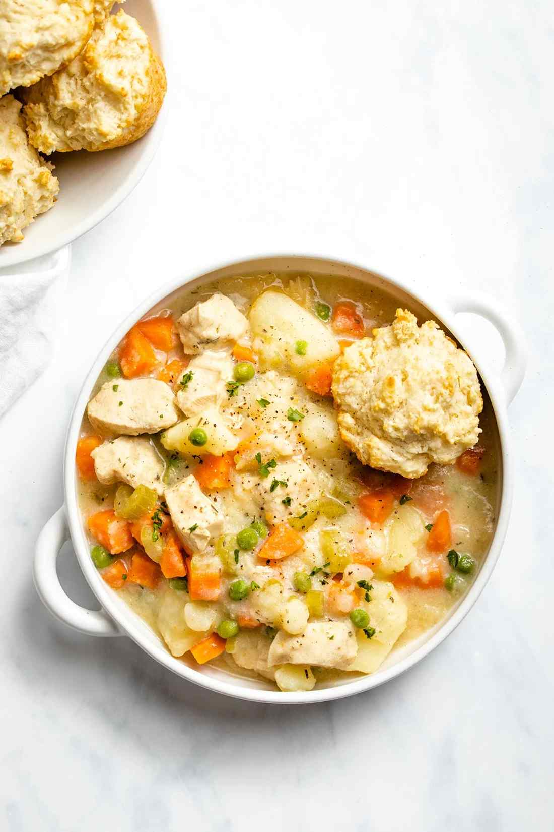 Instant Pot chicken pot pie soup with creamy broth, tender chicken, carrots, peas, potatoes, and a flaky pastry crust topping