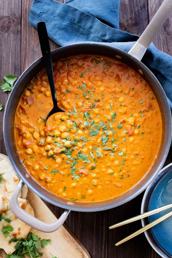 Rich coconut chickpea curry with a golden sauce, fresh cilantro, and a drizzle of lime, served over steaming rice.