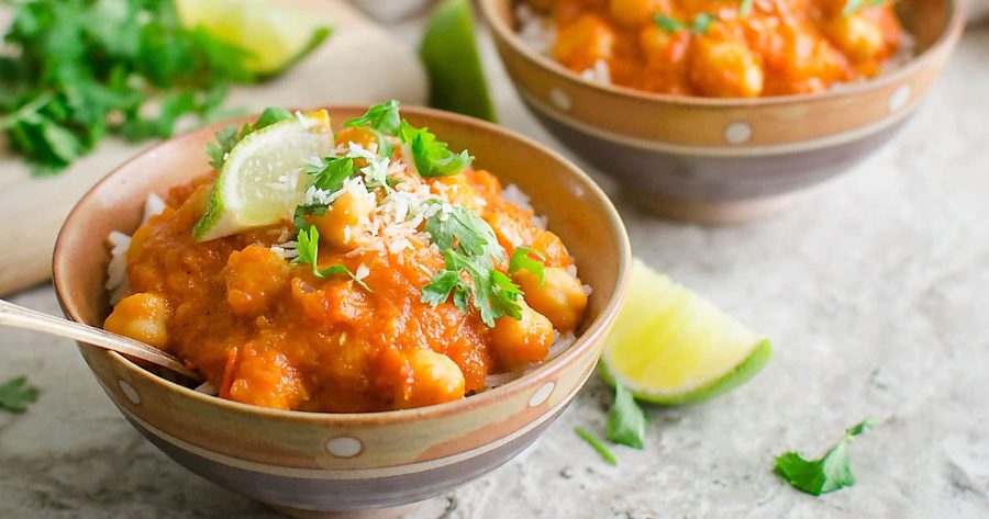 Silky coconut chickpea curry with a bright orange sauce, fresh cilantro, and a lime squeeze, served over jasmine rice.