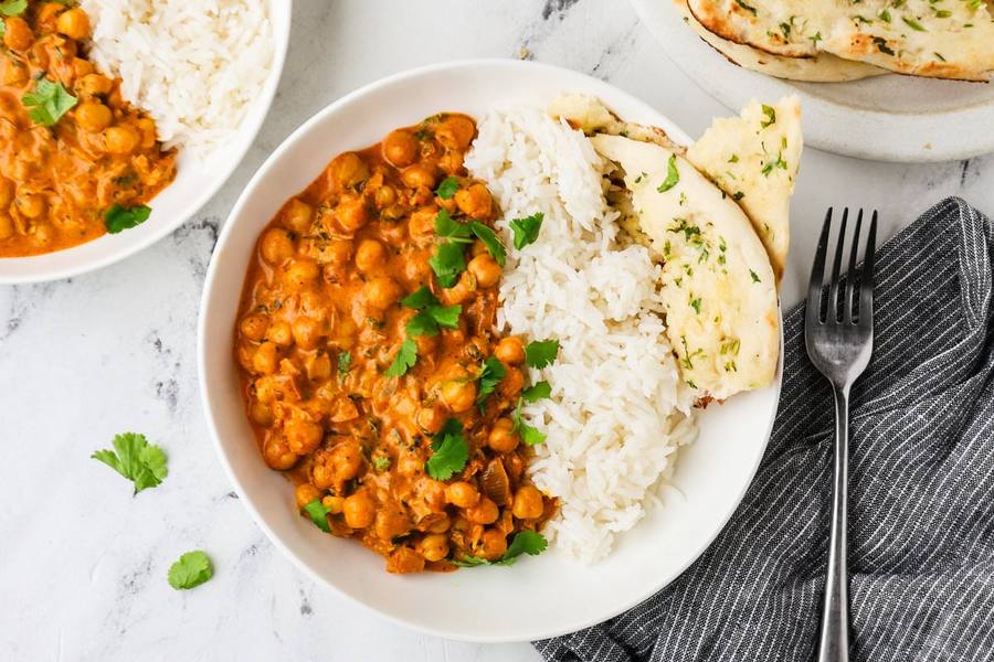Tangy tomato masala chickpea curry with aromatic spices, served over rice, garnished with cilantro