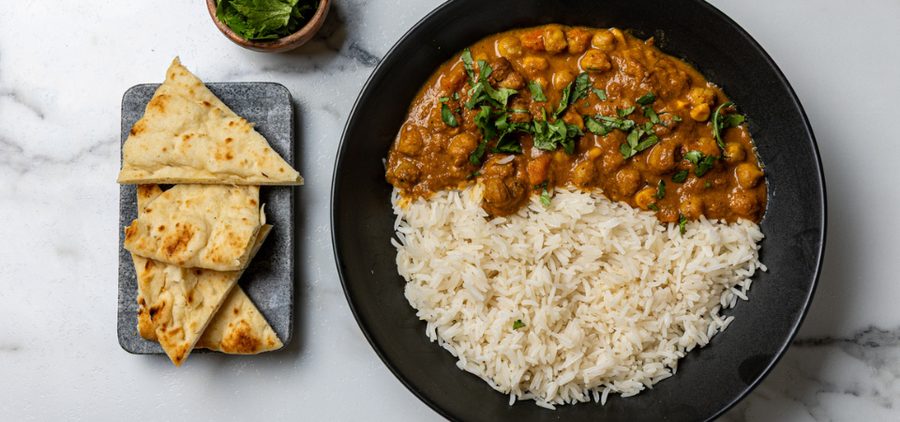 Creamy chickpea curry with almond paste, spices, cream, served with rice and cilantro garnish
