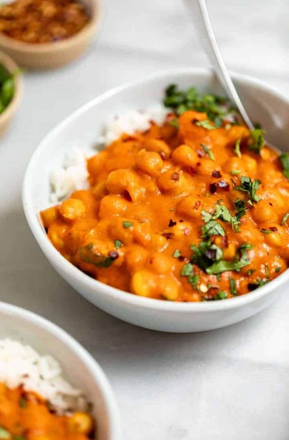 Thai red chickpea curry loaded with sliced peppers in coconut sauce with jasmine rice and cilantro.