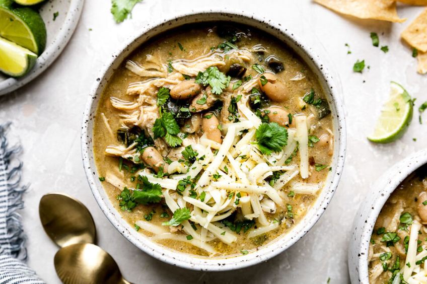 Roasted poblano white chicken chili with sour cream and fresh cilantro in a rustic bowl