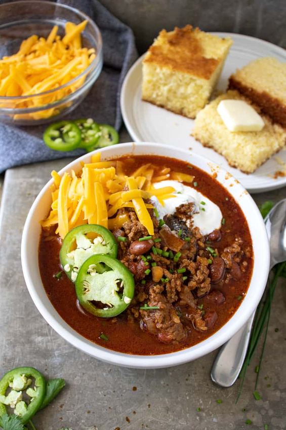 Classic chili con carne with beef, beans, melted cheese, sour cream, jalapenos, sweet cornbread crumble