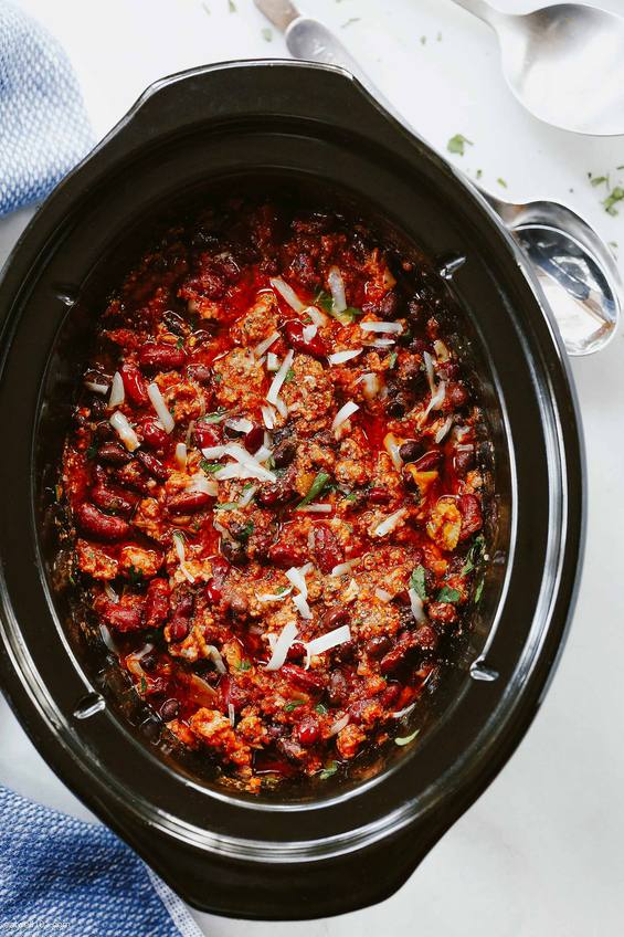 Warm bowl of slow‑cooker beef chili with beans, melted cheese, sour cream, jalapenos, beer infusion