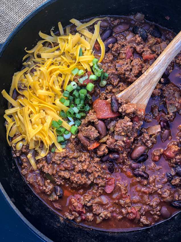 Dutch oven beef chili with beans, melted cheese, sour cream, jalapenos, coffee‑ancho infusion