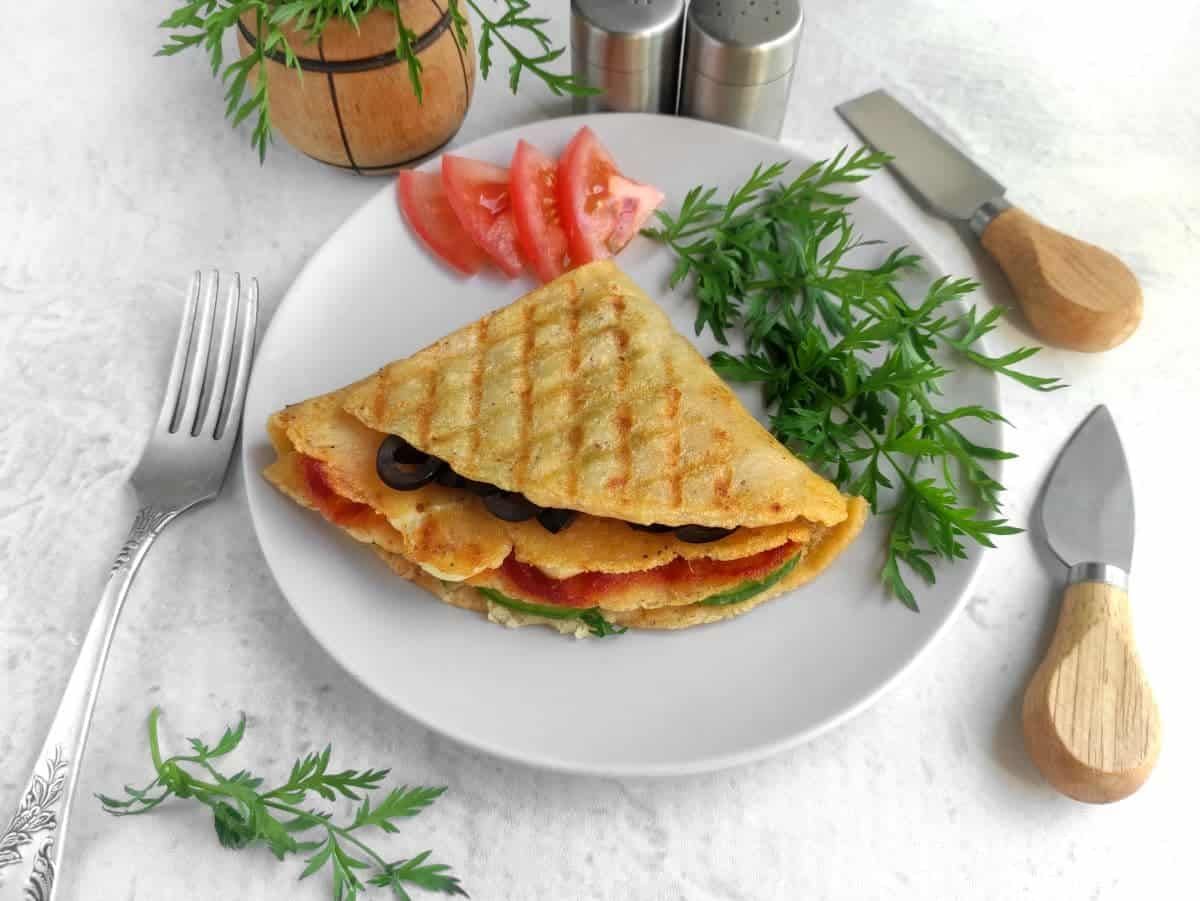 Mini quesadilla triangles toasted on a grill, oozing melted cheese and salsa