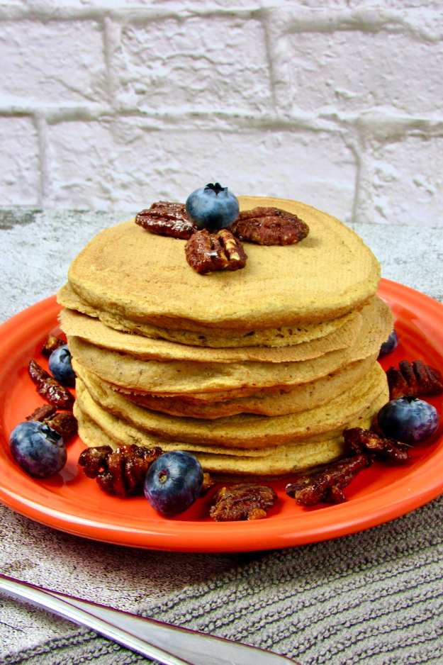 Fluffy pancakes dotted with toasted pecans, cinnamon, and a handful of blueberries