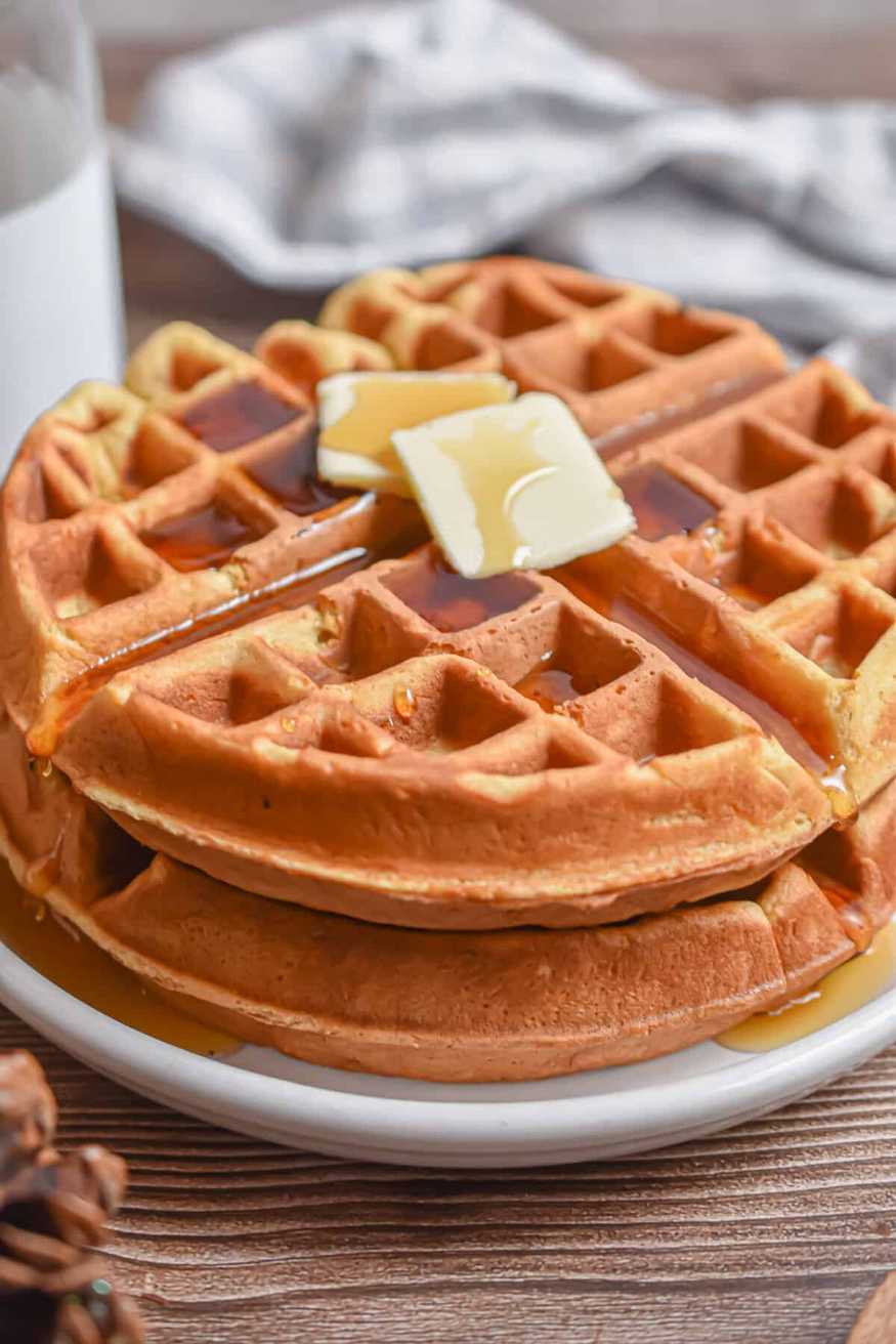 Crispy golden Belgian waffles topped with a pat of herb‑infused butter