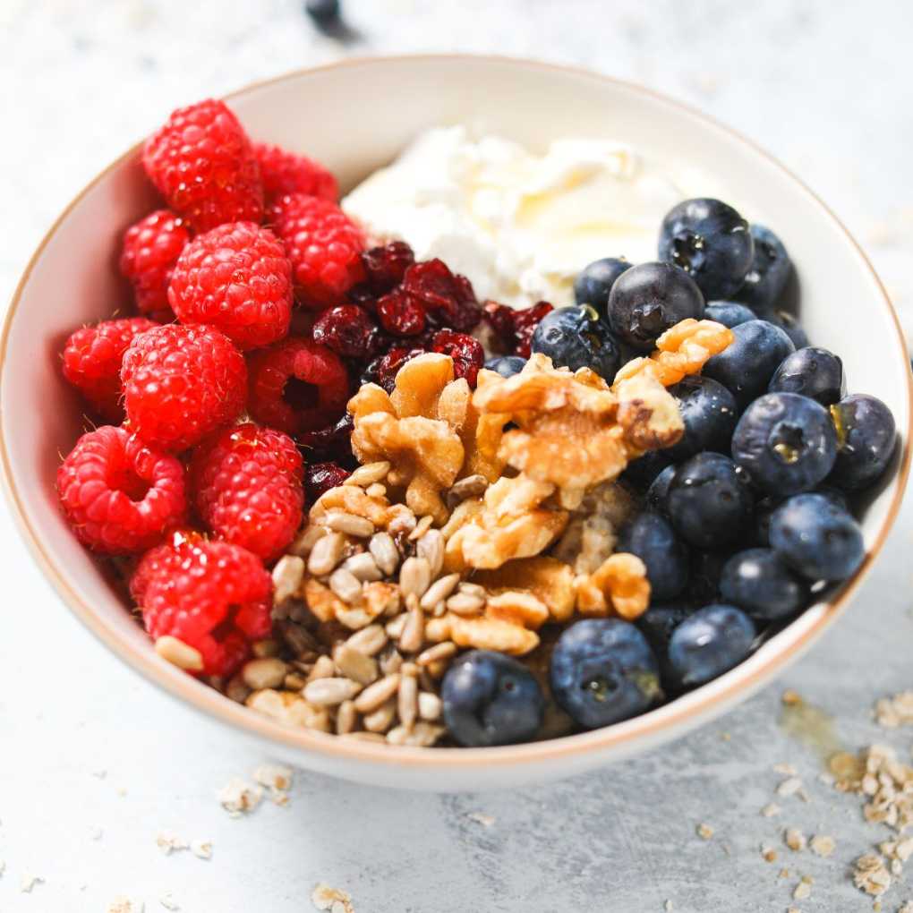 Creamy oatmeal topped with Greek yogurt, fresh berries, and crunchy walnuts