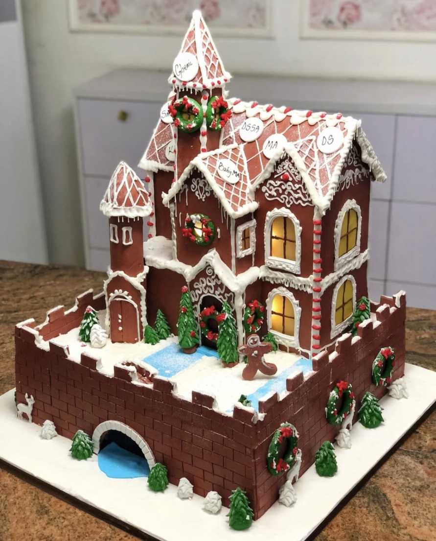 Towering gingerbread castle cake with candy turrets, icing snow, and caramel moat