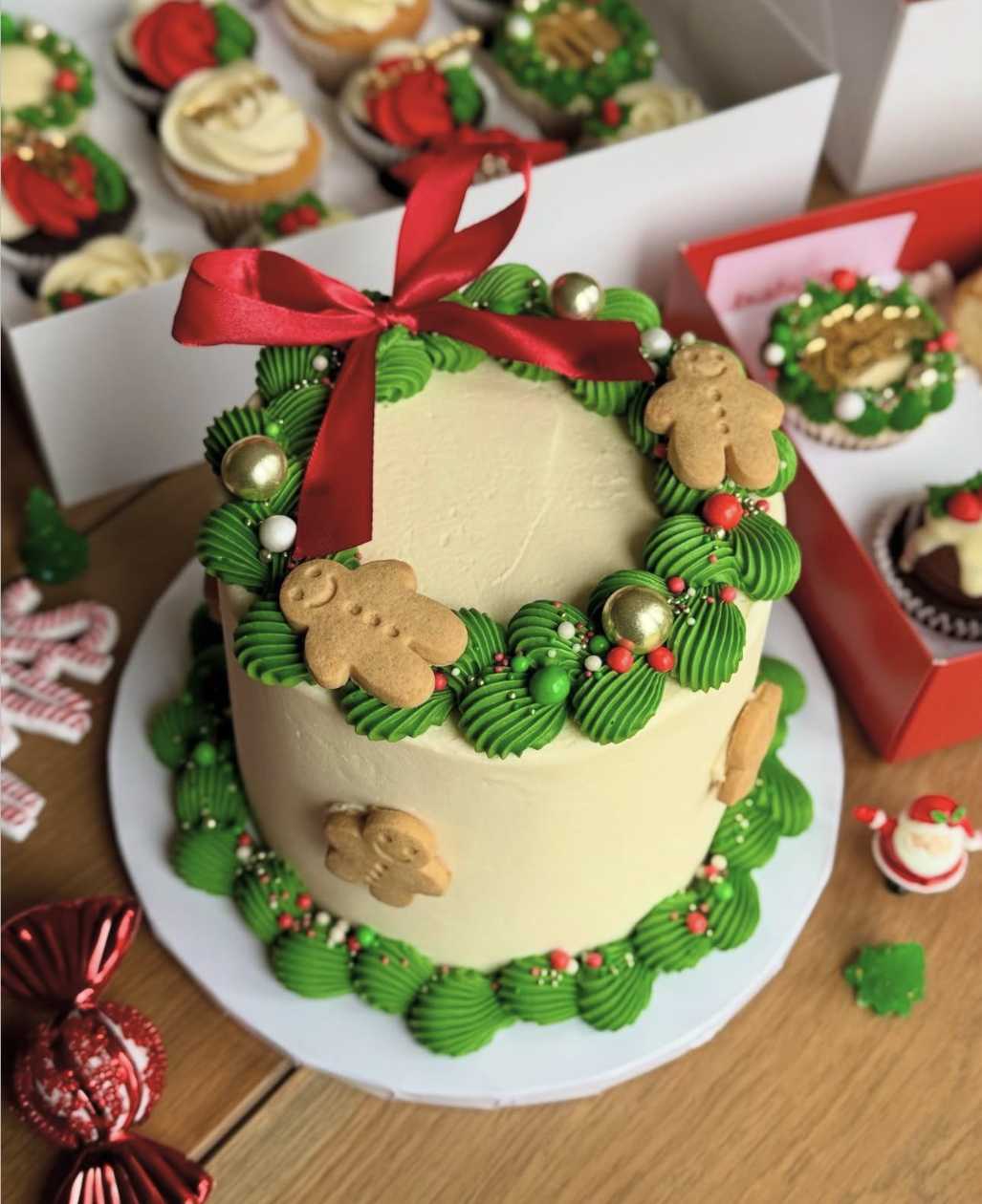 Spiced gingerbread cake with a piped buttercream wreath and gingerbread cutout ornaments