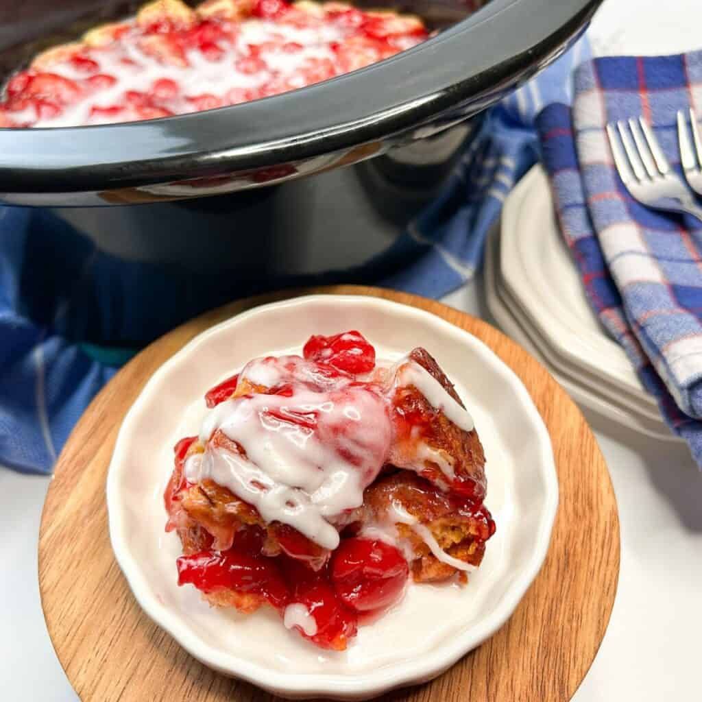 Rustic cherry cobbler with bubbling topping, golden crust, and a sprinkle of powdered sugar