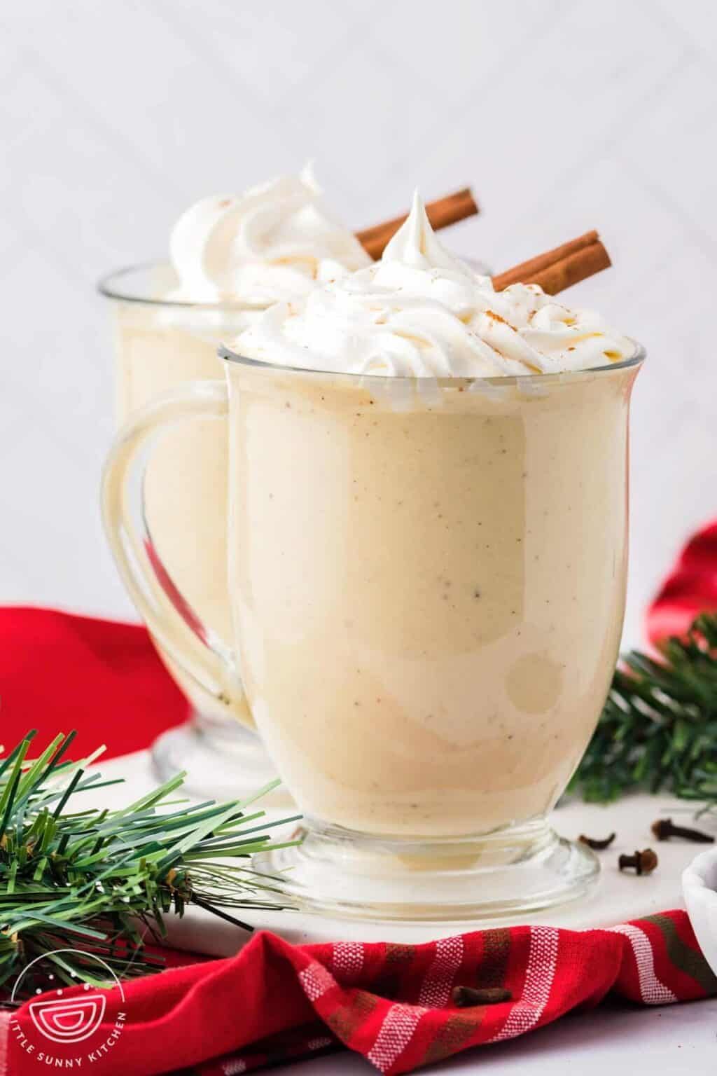 Creamy eggnog poured into glasses, dusted with nutmeg and topped with a cinnamon stick
