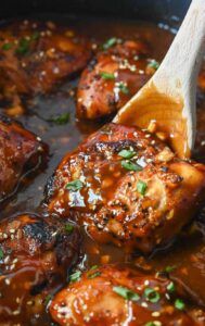Glazed chicken thighs coated in a sticky honey‑garlic sauce, garnished with sesame seeds