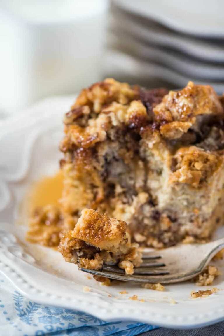Golden baked French toast squares topped with toasted pecans, powdered sugar, and maple drizzle