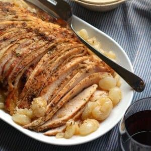 Tender turkey slices nestled among caramelized pearl onions, drizzled with herb gravy