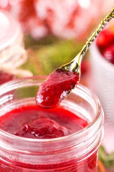 Creamy cranberry butter in a small dish, swirled with a dusting of cinnamon and orange zest