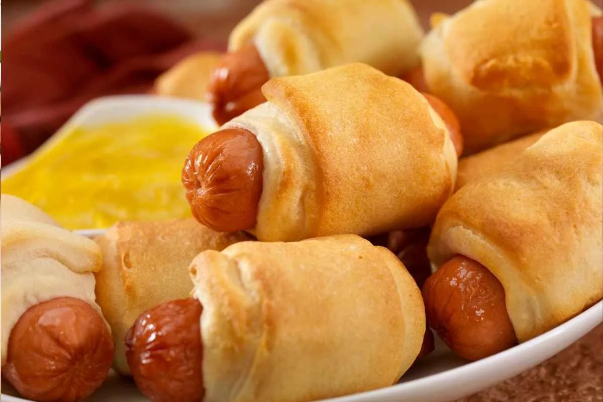 Golden crescent rolls wrapped around mini hot dogs, served with tangy mustard dip