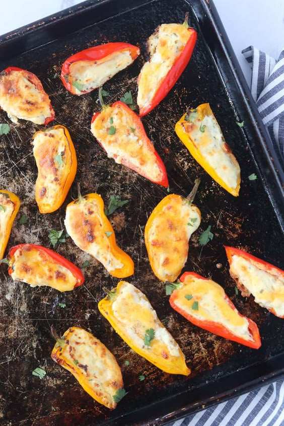 Roasted mini bell peppers filled with melted cheese and herbs, golden brown edges