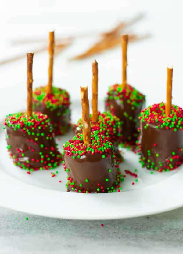 Pretzel sticks dipped in chocolate, topped with toasted marshmallows and sprinkles