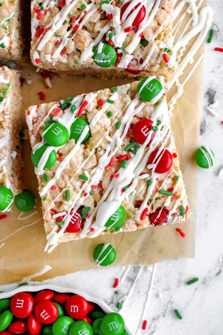 Golden rice krispie squares studded with red and green M&M’s, drizzled with white chocolate