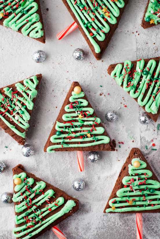 Fudgy brownie squares shaped like trees, topped with crushed candy canes and green frosting