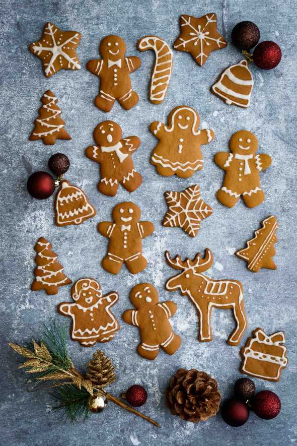 Frosted gingerbread men, stars, and trees arranged on a festive platter