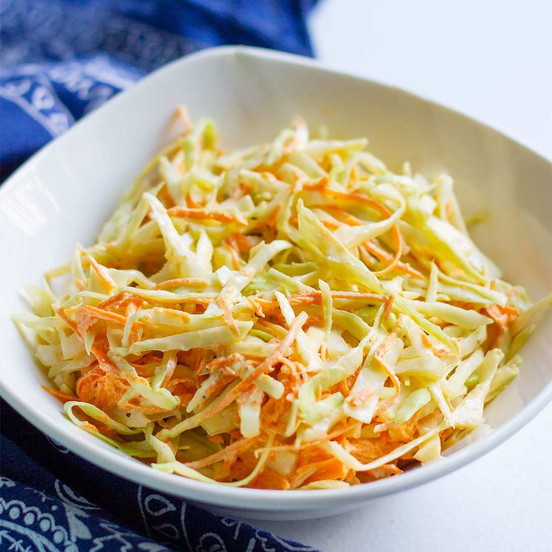 Classic diner creamy coleslaw showing crisp cabbage, rich dressing, and refreshing cool crunch.