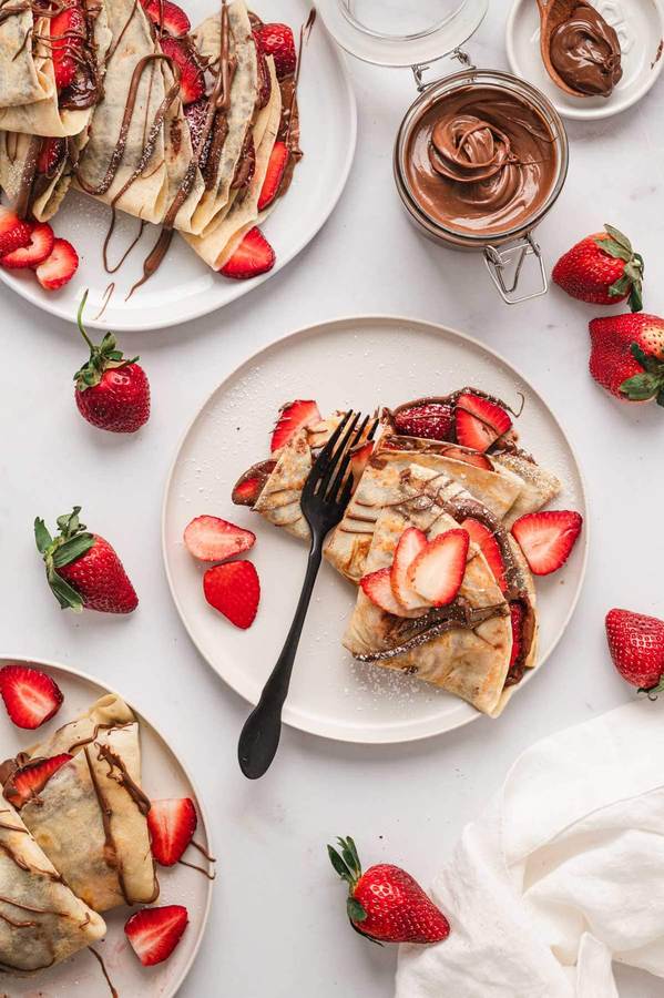 Thin golden crepes swirled with Nutella, topped with chocolate flakes and a dusting of powdered sugar