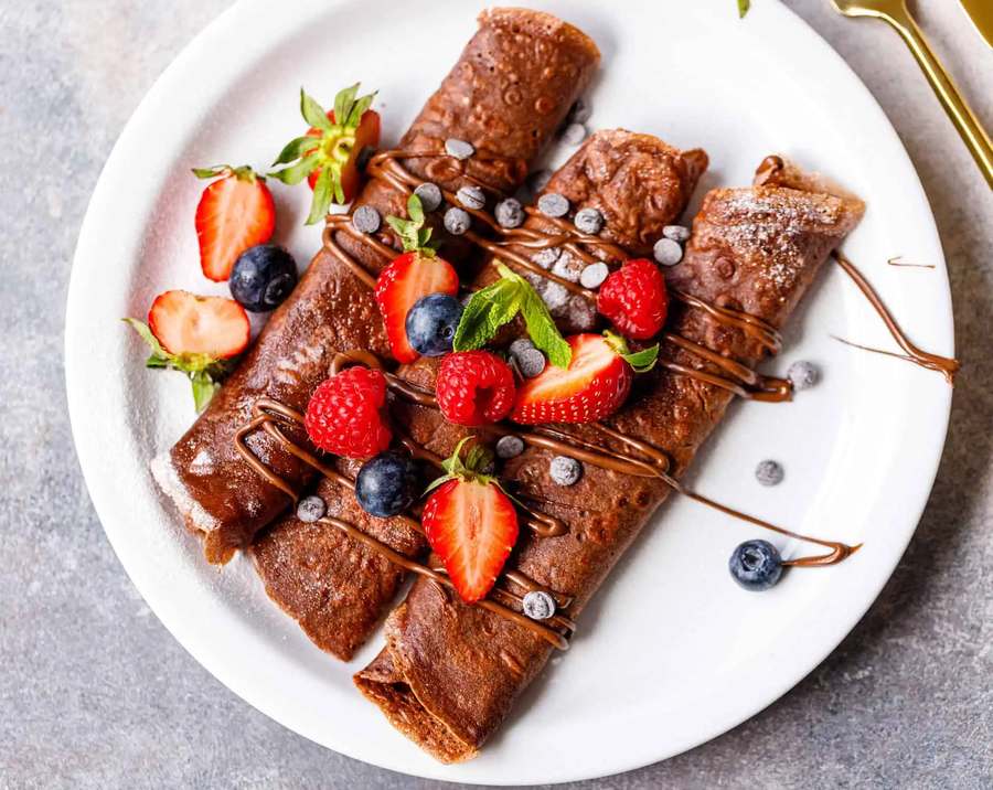 Thick chocolate crepes layered with Nutella, topped with melted chocolate and a drizzle of caramel
