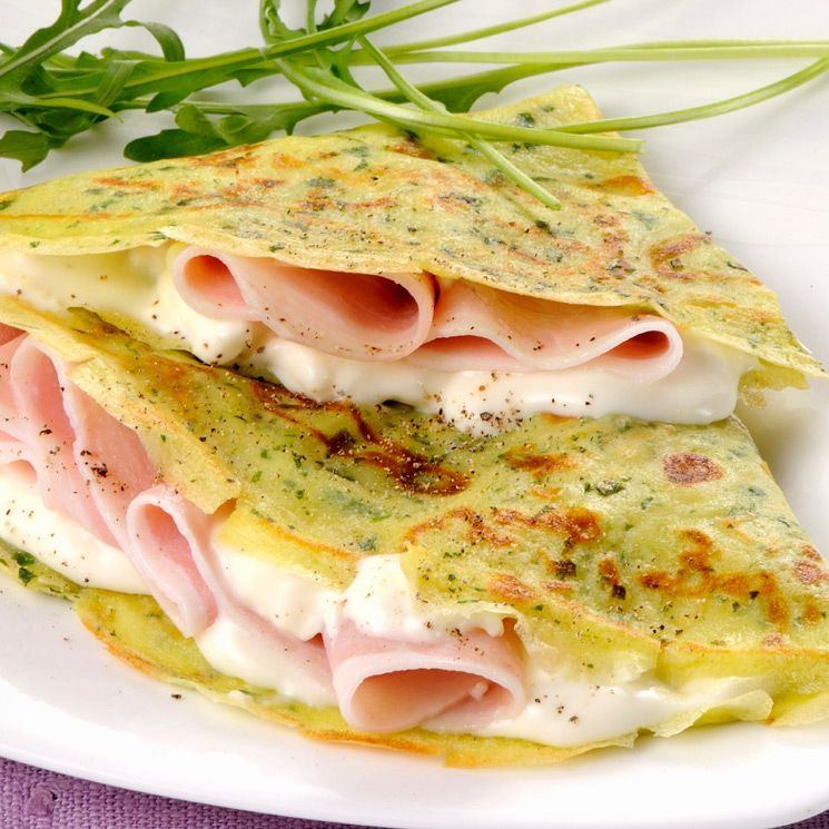 Golden crepes layered with strawberries, blueberries, and a touch of honey, served on a rustic plate