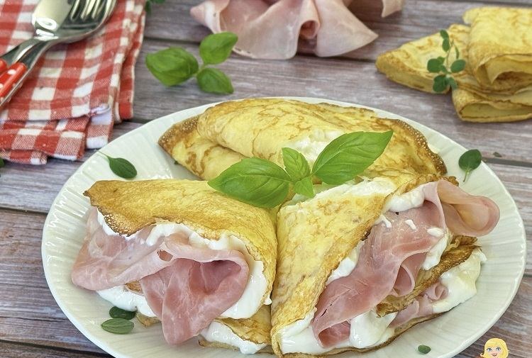 Golden crepes topped with blackberries and a citrus vinaigrette, served on a silver platter