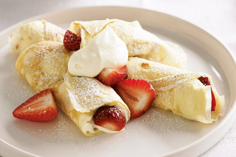 Golden crepes layered with velvety strawberry whipped cream and a sprinkle of toasted almond slivers